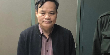 Cơ quan điều tra tống đạt lệnh bắt tạm giam giám đốc CDC Bắc Giang Lâm Văn Tuấn - Ảnh: GIANG LONG