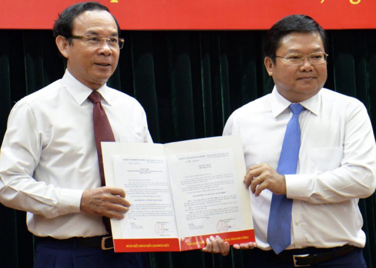 Bí thư Thành ủy Nguyễn Văn Nên (trái) trao quyết định cho ông Lê Văn Thinh.