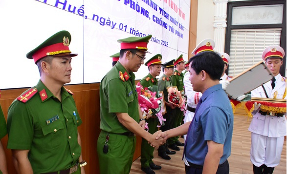Ông Nguyễn Văn Phương - chủ tịch UBND tỉnh Thừa Thiên Huế - trao bằng khen cho lực lượng công an tỉnh này khi có thành tích phá án vụ cướp tiệm vàng bằng súng quân dụng ngày 31-7 - Ảnh: NG. MINH